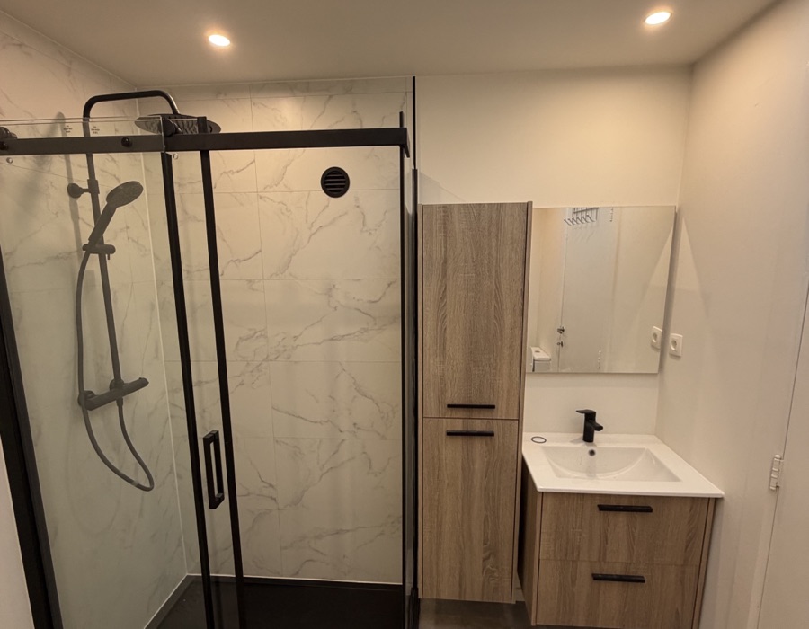 Nieuwe badkamer na de renovatie, met inloopdouche en zwarte kranen